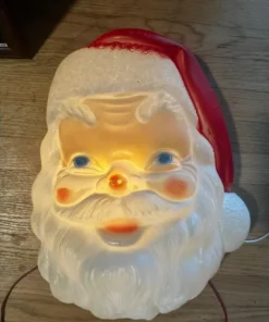Illuminated wall decoration featuring a vintage, blow-molded, red Mid-Century Santa Claus face